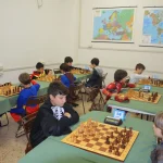 Numerosi bambini giocano a scacchi al torneo di carnevale