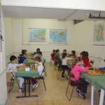 Numerosi bambini giocano a scacchi al torneo di carnevale