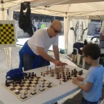 L'istruttore Silvio Brozzi insegna gli scacchi ad un bambino nell'ambito della manifestazione