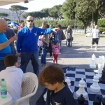 L'istruttore Silvio Brozzi accanto alla scacchiera gigante con i ragazzi, presso lo stadio dei Marmi in Roma